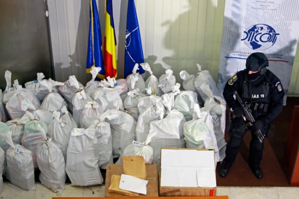 루마니아 특수경찰대원이 26일(현지시간) 루마니아 수도 부쿠레슈티의 조직범죄 및 테러수사국(DIICOT) 건물에서 열린 기자회견 중 압수한 코카인 가방을 지키고 있다. 루마니아 경찰은 다뉴브 삼각주에서 1톤이 넘는 고순도 코카인을 압수했으며 이는 암시장에서 미화 3억4,000만 달러(한화 약 3,900억 원)에 달하는 규모라고 밝혔다.