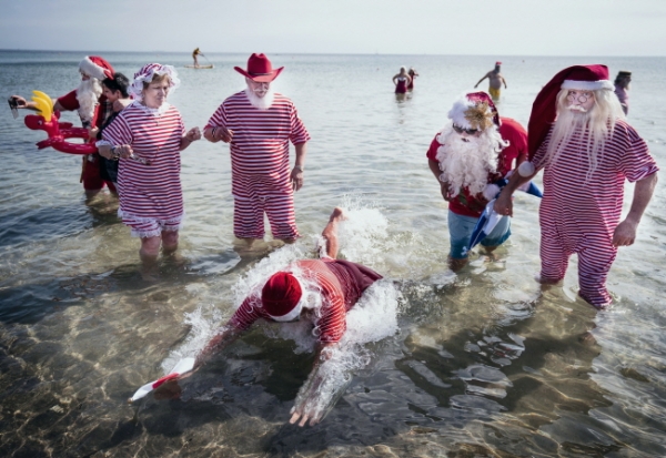 23일(현지시간) 덴마크 수도 코펜하겐 인근 벨뷰 스트란드 해변에서 연례 국제 산타클로스 총회가 열려 참가자들이 소금물 족욕을 즐기고 있다. 연례 산타 총회는 25일까지 이어진다.