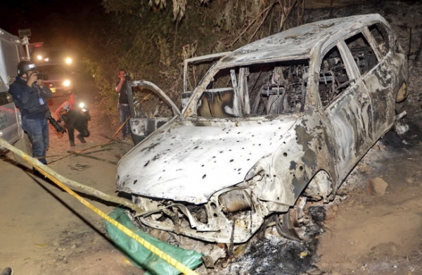 2일(현지시간) 콜롬비아 수아레스 시장 후보 카리나 가르시아가 살해돼 불에 탄 차에서 발견된 가운데 사진기자들이 현장에서 피해 차량을 찍고 있다. 가르시아는 일행인 여성 후보 5명과 함께 불에 탄 차량에서 숨진 채 발견됐으며 사망자 중에는 가르시아 후보의 모친과 시의원 후보도 포함돼 있었다. 경찰은 지난 1일 밤 반체제 좌익 반군으로 보이는 범인들이 이들의 차량을 습격해 가르시아와 일행을 살해한 뒤 차에 불을 지른 것으로 추정하고 있다.