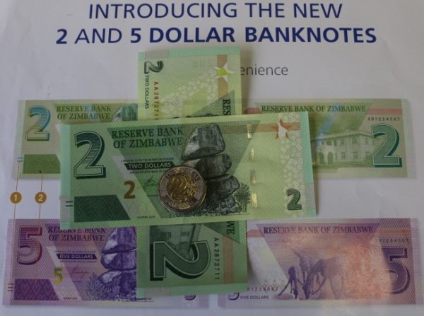 12일(현지시간) 짐바브웨 수도 하라레에서 짐바브웨 예비은행(RBZ)이 새로 발행한 2달러, 5달러짜리 지폐와 2달러짜리 본드 코인을 새로 발행된 2달러 본드 코인이 소개되고 있다. 짐바브웨 은행들은 현재의 자금난을 완화하기 위해 화요일부터 유통하기 시작했다. 2009년 극심한 인플레로 타격을 입은 국내 통화를 대체하기 위해 미국 달러를 공용화폐로 사용했던 짐바브웨는 지난 6월 미국 달러의 사용을 금지하고 다시 자국 화폐를 채택했다. /뉴시스