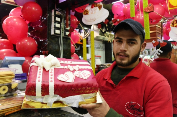 12일(현지시간) 시리아 수도 다마스쿠스에서 밸런타인 시즌을 맞아 한 제빵사가 자신이 만든 케이크를 들어 보이고 있다. /뉴시스