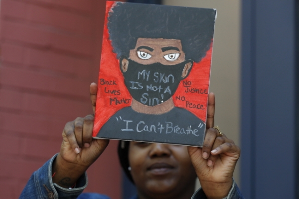 7일(현지시간) 미국 뉴욕 브루클린 인근에서 조지 플로이드를 죽음에 이르게 한 경찰 폭력에 항의하는 한 여성이 "숨을 쉴 수 없다"라고 쓴 자신이 그린 그림을 들고 시위에 참여하고 있다. 뉴욕시는 주말 시위가 폭력이나 사고 없이 평화적으로 이뤄지면서 야간 통행 금지를 앞당겨 해제했다.  /뉴시스