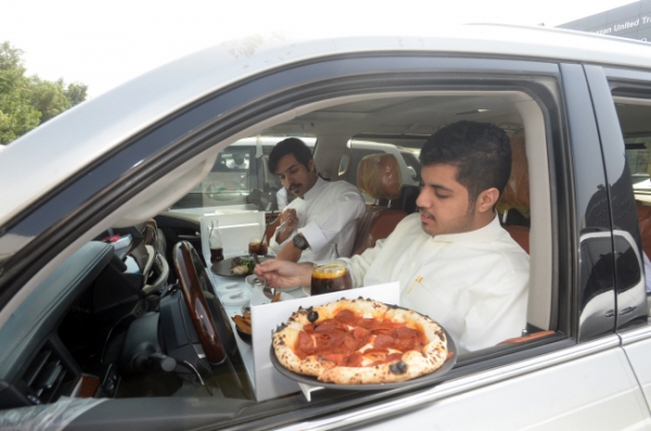 10일(현지시간) 쿠웨이트 수도 쿠웨이트시티의 한 레스토랑 밖에서 손님들이 주차된 자신의 차 안에서 점심을 먹고 있다. 쿠웨이트 정부가 코로나19 확산을 억제하기 위해 식당 내 식사를 금지하면서 식당들은 손님을 받기 위한 방법으로 자동차까지 배달해주는 서비스를 제공하기 시작했다.  /뉴시스