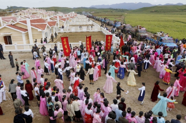 우와 강풍으로 피해를 입었던 황해북도 금천군 강북리에서 주민들이 신축 주택에 입주하기 전 춤을 추며 축하하고 있다. /뉴시스
