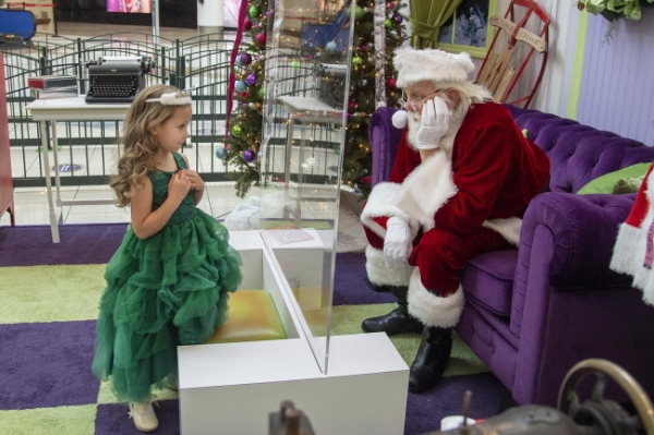 24일(현지시간) 미 뉴저지주 체리 힐의 체리 힐 몰에서 산타클로스의 날 행사가 열려 5세 된 한 소녀가 가림막을 사이에 두고 산타를 만나 소원을 말하고 있다. /뉴시스