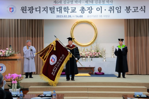김윤철 원광디지털대 제7대 총장이 28일 원광대 숭산기념관에서 개최된 취임식에서 교기를 흔들고 있다.